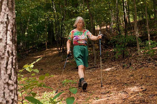 Senior woman hiking on a wooded trail