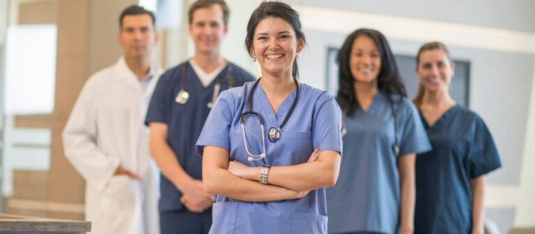 Smiling healthcare staff in scrubs at a facility