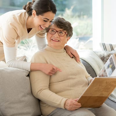Smile shared between caregiver and resident in a cozy living area