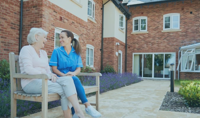 Staff member chatting with resident in the garden