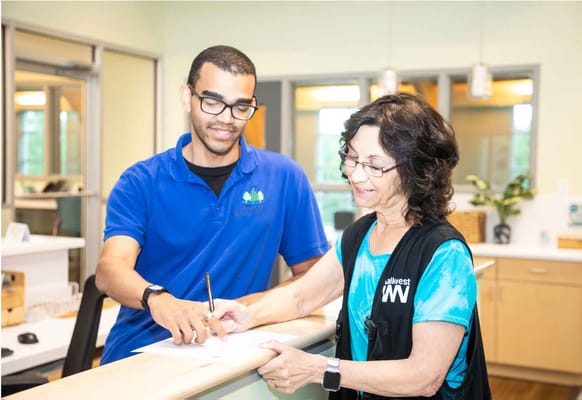 Staff assisting a resident at the reception.