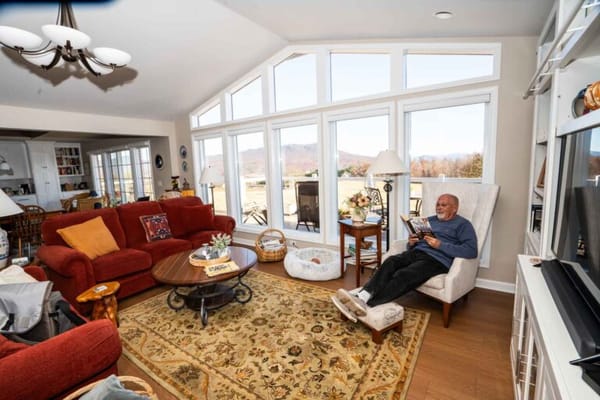 Resident relaxing in a cozy living room with large windows