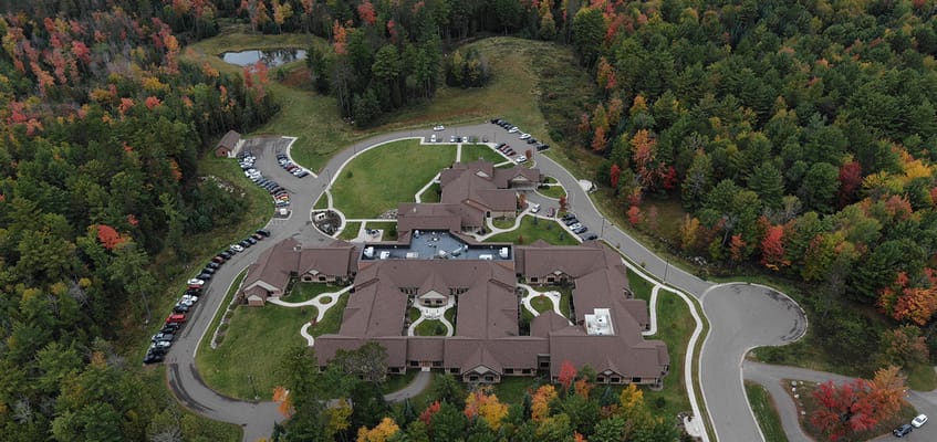 Aerial view of a senior living facility surrounded by trees