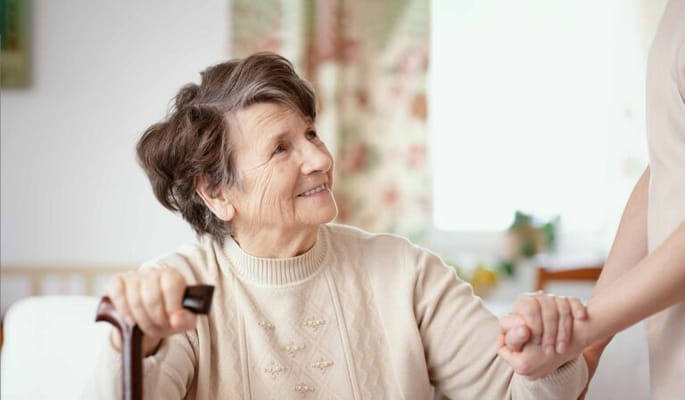 A resident smiling while interacting with staff