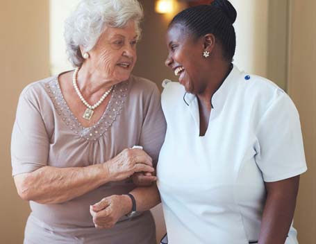 Resident and staff sharing a joyful moment in the facility