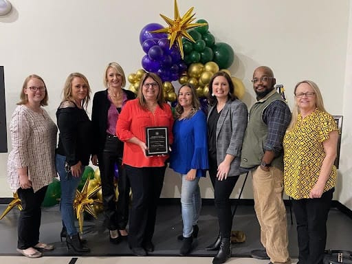 Staff members celebrating an award in a decorated room