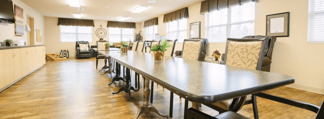 Bright activity room with long table and comfortable chairs