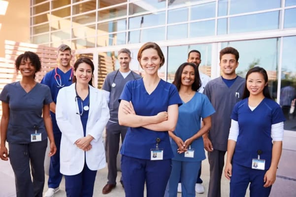 Staff members in uniforms posing outside the facility