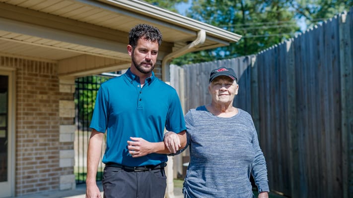 A staff member assisting a resident outdoors