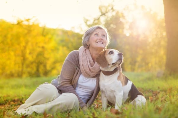A senior woman enjoying time with her dog outdoors