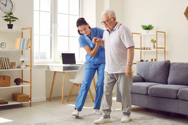 Staff assisting a resident in a well-lit living room