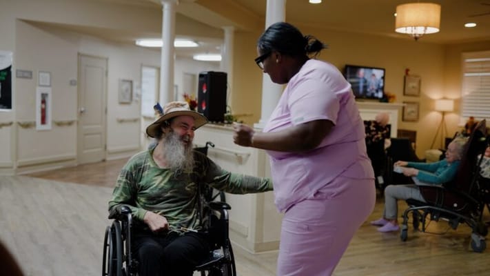 Staff member dancing with a resident in a common area