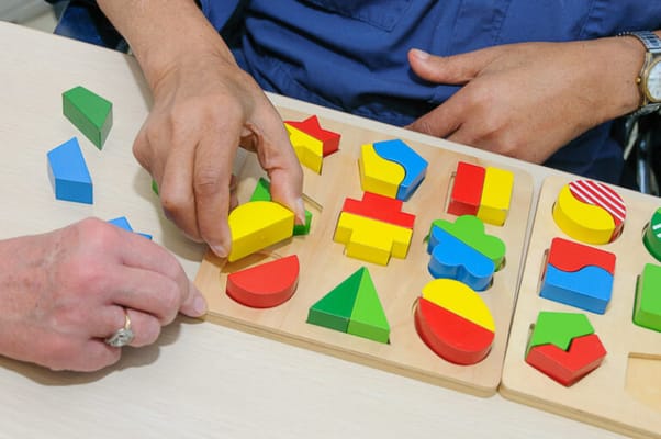 Two hands working with colorful puzzle pieces
