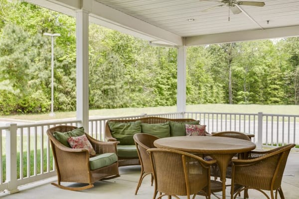 Outdoor seating area with greenery in the background