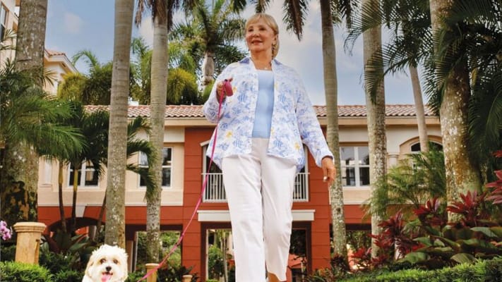 Resident walking a dog in the garden area