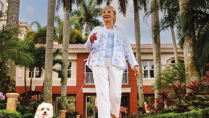 Resident walking a dog in the garden area