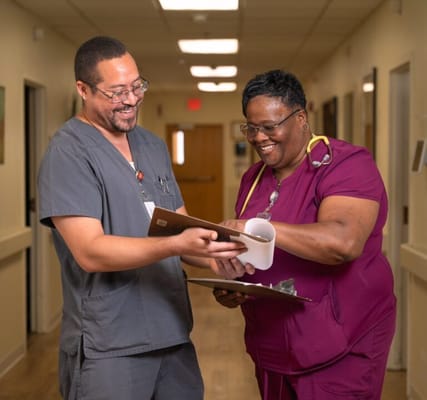 Two nursing staff discussing in a hallway