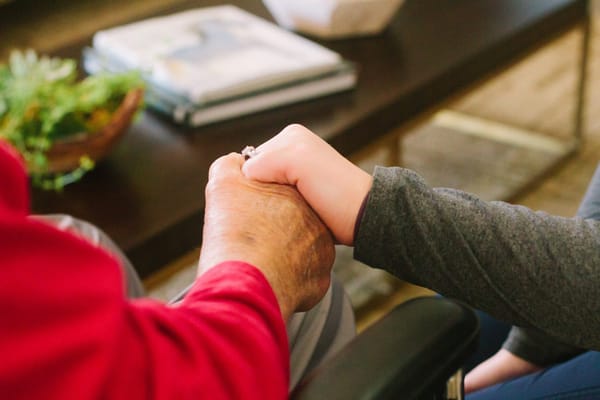 Two hands holding in a cozy indoor setting