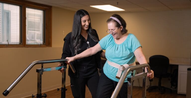 Resident practicing mobility with staff assistance