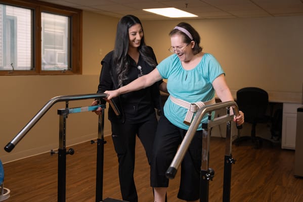 Staff assisting resident during physical therapy