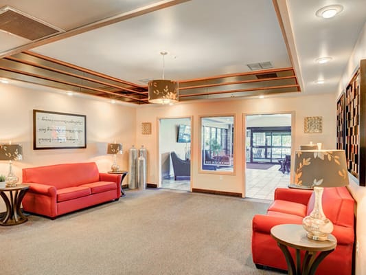 Bright common area with red sofas and lamps