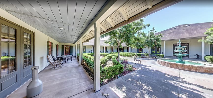 Patio area with landscaped gardens and a fountain