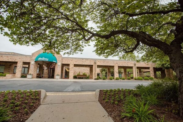 Exterior view of Delmar Gardens with lush landscaping