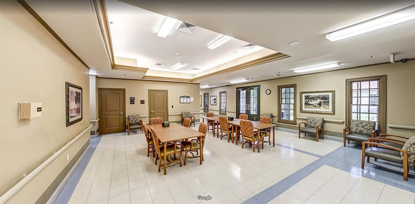 Bright common area with tables and chairs for residents