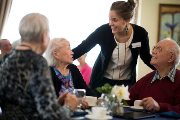 Staff interacting with residents in a dining area