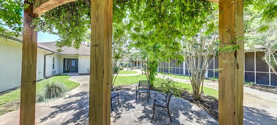 Outdoor seating area surrounded by greenery in the facility garden