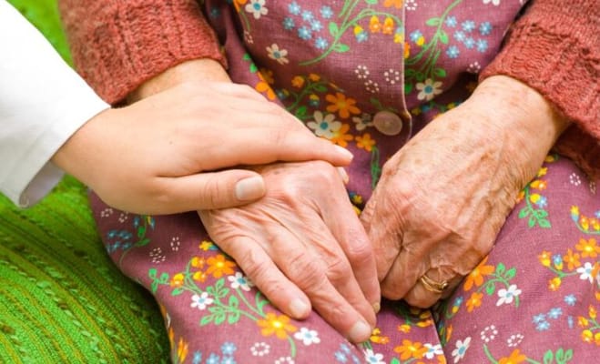 Caregiver holding a resident's hand