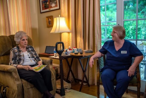 Resident and staff member conversing in a cozy lounge