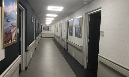 Well-lit corridor with framed artwork on the walls
