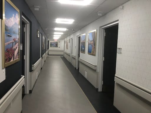 A well-lit corridor with framed artwork on the walls