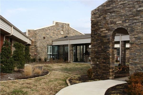 Exterior view of Crowley Ridge Care Center with pathways and stone structure