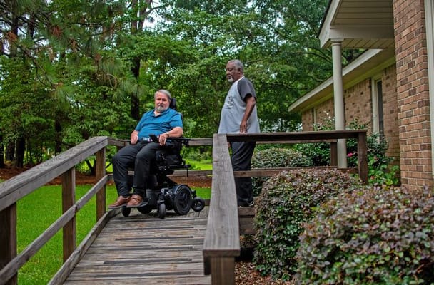 Resident in a wheelchair with staff member outdoors