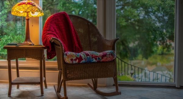 Cozy rocking chair by a window with a lamp