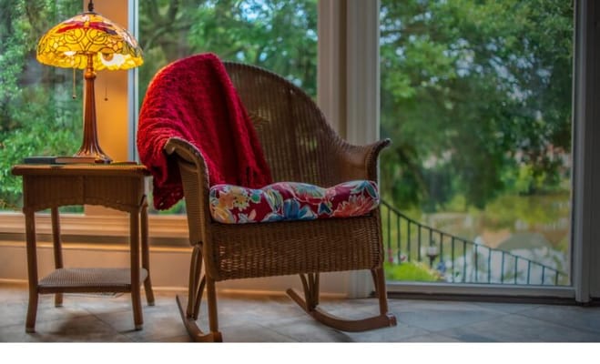 Cozy rocking chair with a lamp and red blanket