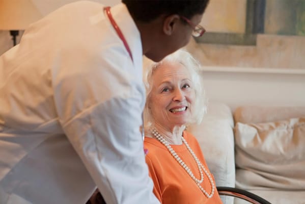 A caregiver interacting with a smiling resident in a cozy setting