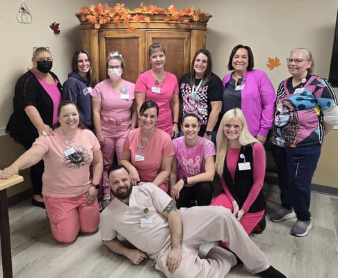 Staff members posing together in a decorated common area