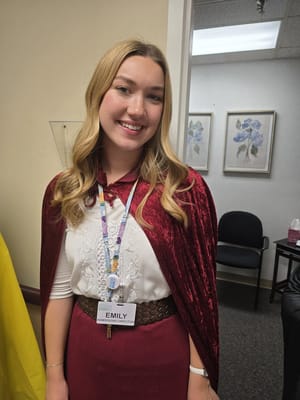 Staff member in a cape at an event