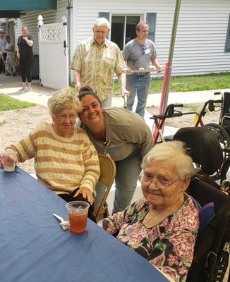 Residents enjoying an outdoor gathering with staff