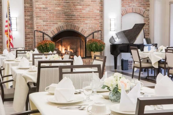 Elegant dining room setup with a fireplace and piano