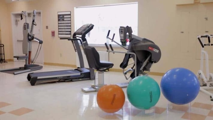 Well-equipped fitness room with exercise machines and balls