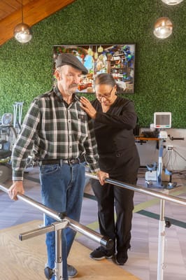 A staff member assisting a resident with rehabilitation exercises
