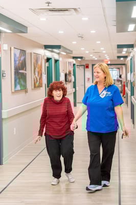 Staff escorting a resident in a hallway