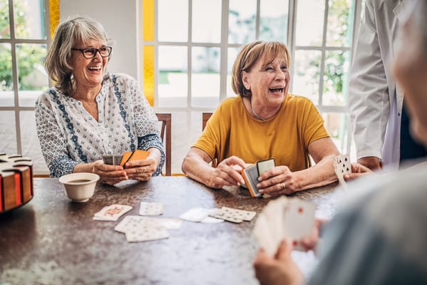 Residents enjoying a card game in a lively activity room