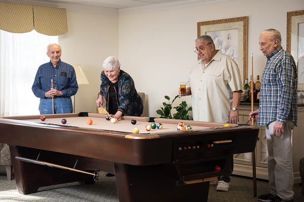 Residents enjoying a game of billiards in a common area