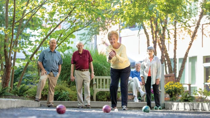 Residents playing bocce ball in a garden
