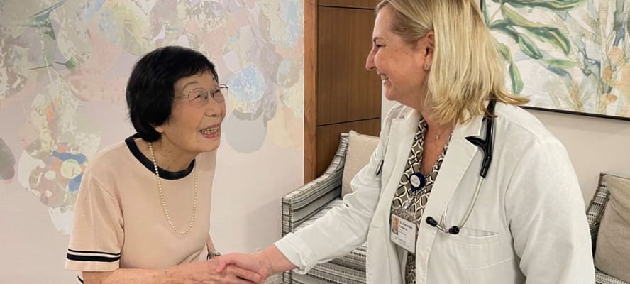 Staff member greeting a resident in a cozy common area